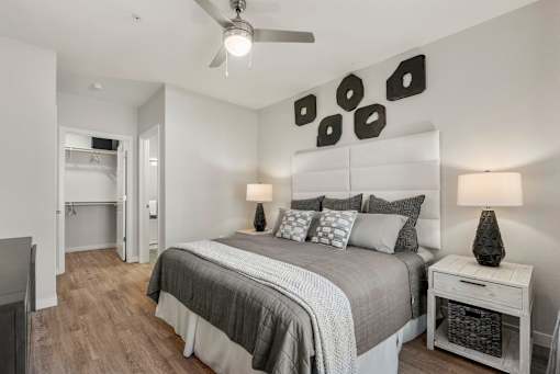 A bedroom with a bed, nightstand, and a ceiling fan.