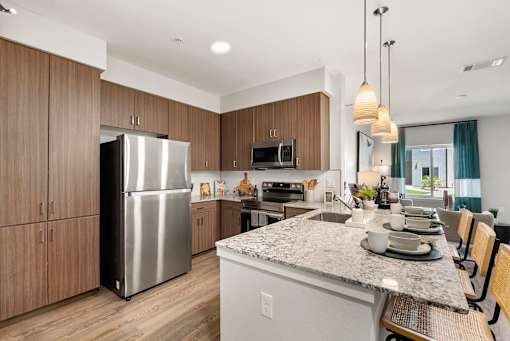 A modern kitchen with a granite countertop and stainless steel appliances.