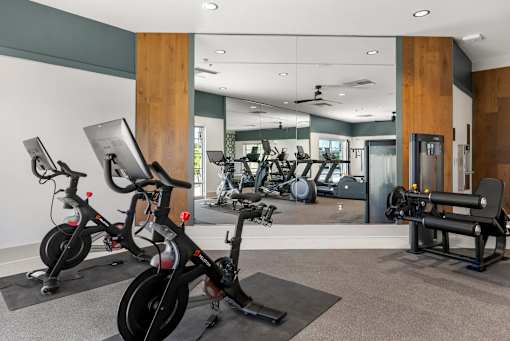 A gym with exercise equipment and mirrors.