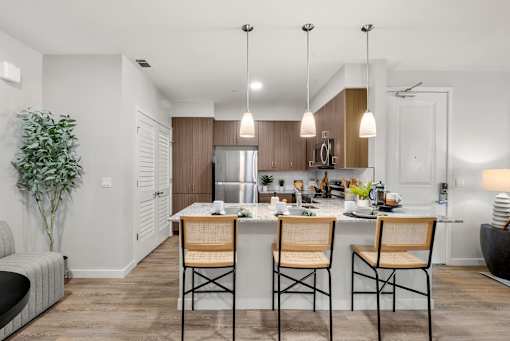 A modern kitchen with a dining table set for two.