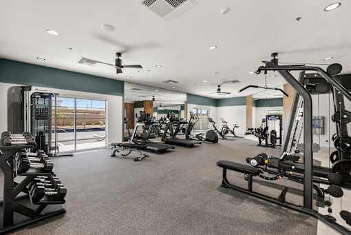 A spacious gym with a variety of equipment including treadmills, weights, and exercise machines.