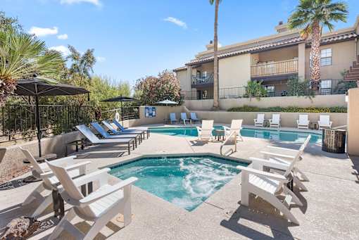 A pool surrounded by chairs and umbrellas.