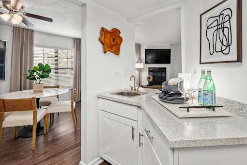 A kitchen with a white countertop and a wooden chair.