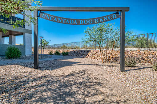 A sign that reads "Uncantada Dog Ranch" stands in front of a fence.