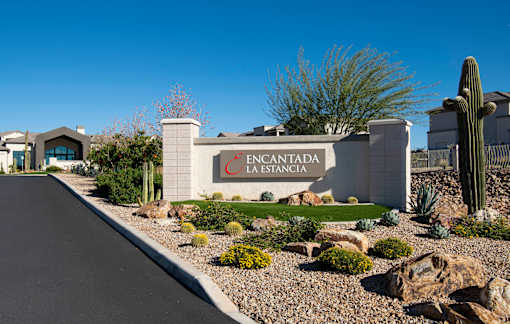 A sign that says "FENCANTADA LA ESTANCIA" in front of a cactus.