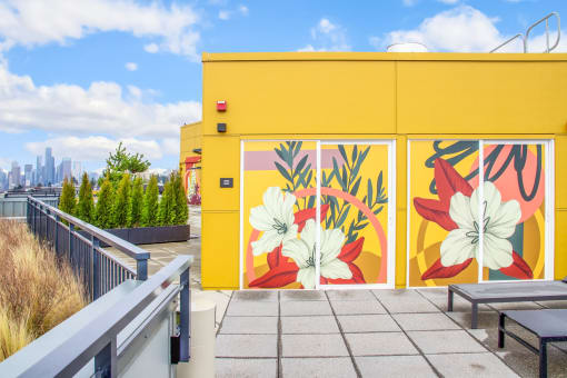 a yellow building with a mural of flowers on it