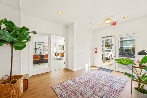 a living room with white walls and glass doors and a rug