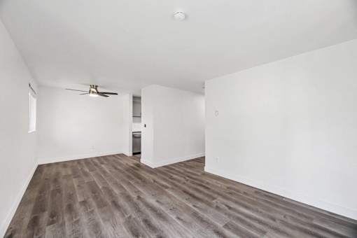 A room with a ceiling fan and wooden flooring.