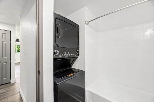 A black oven is built into a white wall.