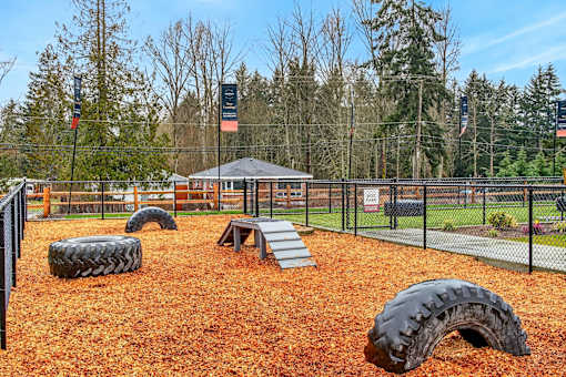 A playground with a tire slide and a wooden platform.