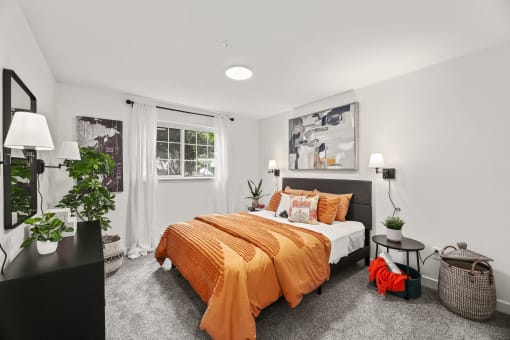 a bedroom with white walls and an orange bed