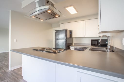 a view of the stainless steel countertop of a kitchen with white walls and ceiling