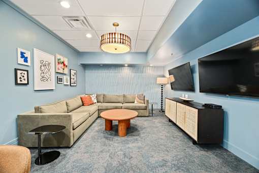 A living room with a couch, a chair, a coffee table, and a television.