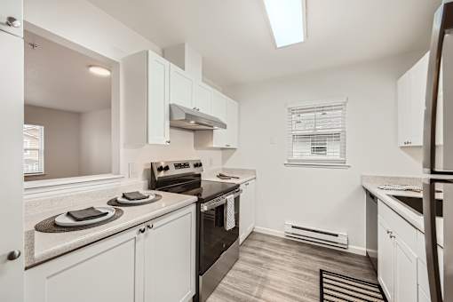 A kitchen with white cabinets and appliances.