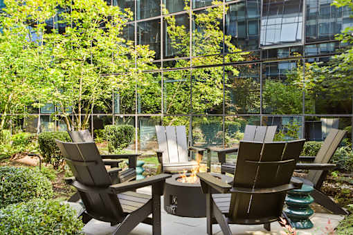 A patio with chairs and a fire pit.