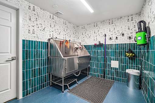 A cleaning machine is in a bathroom with blue tiles.