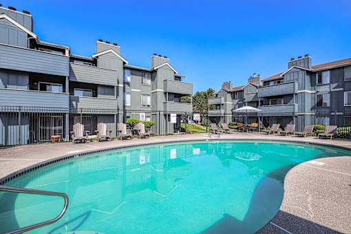 A swimming pool in front of apartment buildings.