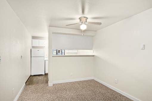 A room with a ceiling fan and a window with blinds.