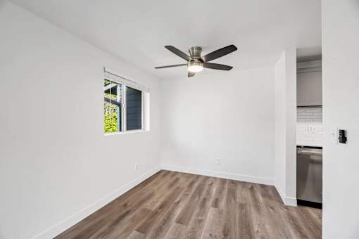 A room with a ceiling fan and a window.