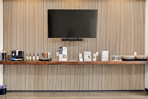 A wall with a television and a shelf with various items on it.