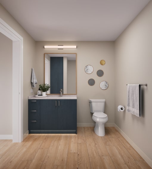 Eugene, OR Luxury Apartments - Heartwood - Bathroom with Ash Blue Vanity, Large Mirror, Wood-Style Flooring, and Beige Walls