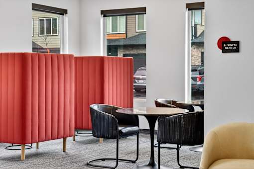 A red panelled wall in a room with a business center sign.
