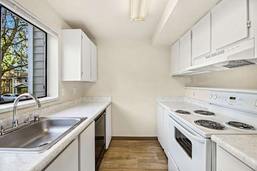 A kitchen with white appliances and cabinets.