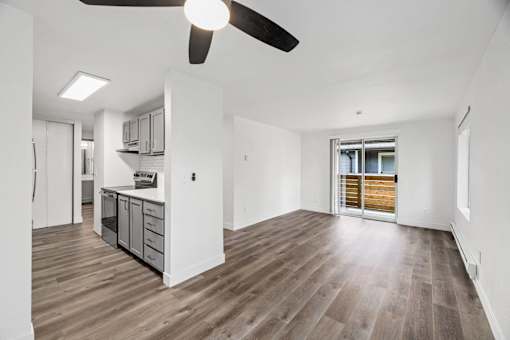 A room with a ceiling fan and wooden flooring.