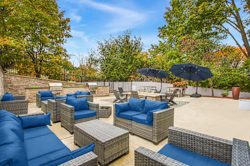 A patio with blue cushions and wicker furniture.
