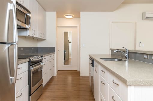 a kitchen with stainless steel appliances and white cabinets