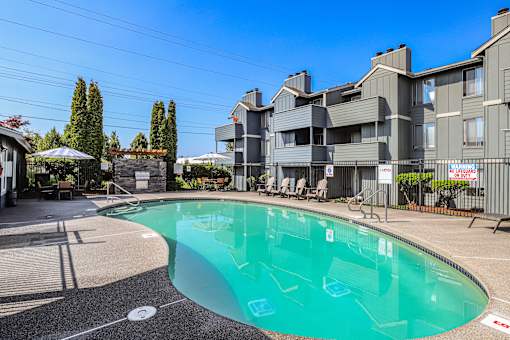 A swimming pool in front of a residential building.