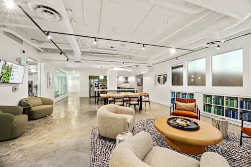 A modern office space with a variety of seating options and a long table.
