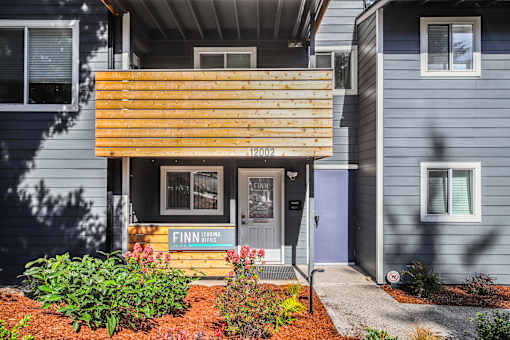 A blue house with a wooden porch and a sign that says "Finn".