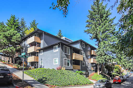 A modern apartment building with a green lawn in front.