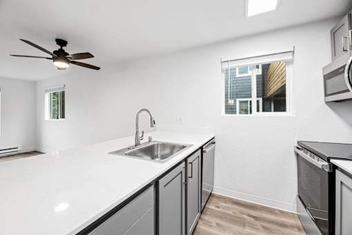 A kitchen with a white countertop and a window.