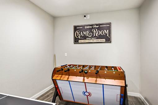 A game room with a pool table and a sign on the wall.