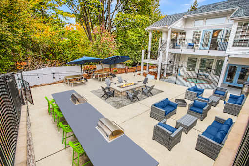 A patio with a table and chairs is surrounded by trees.