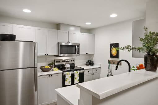 a kitchen with stainless steel appliances and white cabinets