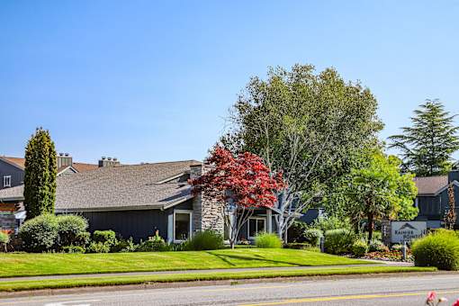 A house with a grey roof and a sign that says "Ranchers" in front of it.