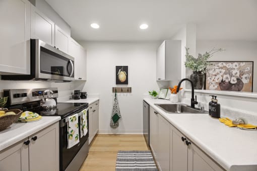 a kitchen with white cabinets and black appliances and a sink