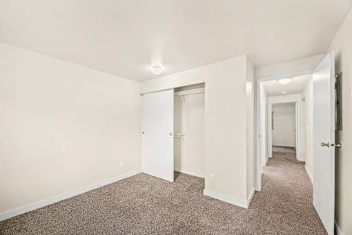 A long hallway with carpeted floors and white walls.
