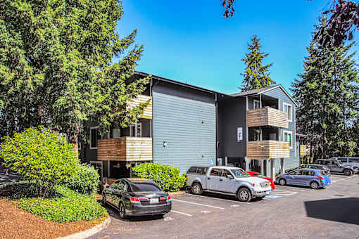 A parking lot with cars and a modern building.