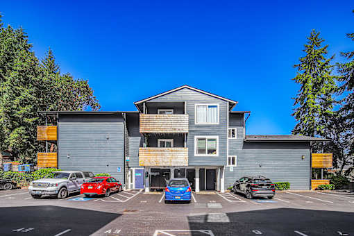 A parking lot with cars and a building in the background.
