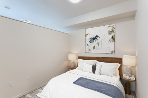 a bedroom with a white bed and a painting on the wall