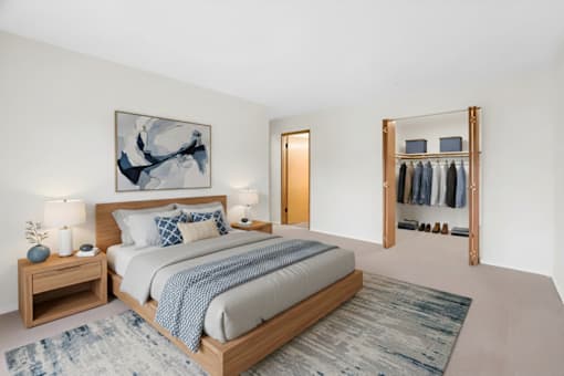 A bedroom with a large bed and a painting on the wall.