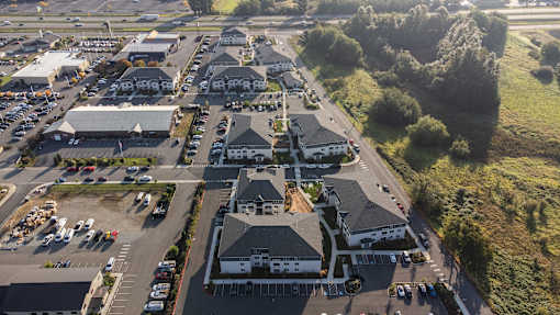 A large building complex with a parking lot in front.