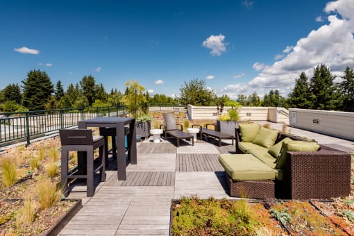a rooftop deck with furniture and a table and chairs