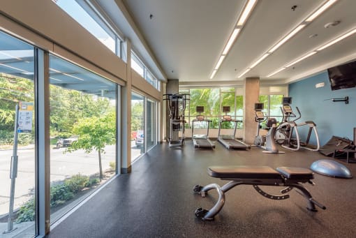 a gym with exercise equipment and a large window