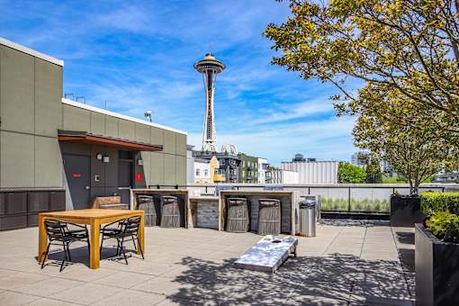 A patio with a table and chairs overlooking a Seattle Space Needle.