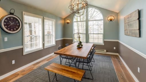 a dining room with a large window and a wooden table